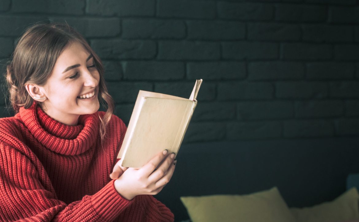 the girl is reading a book in a cafe